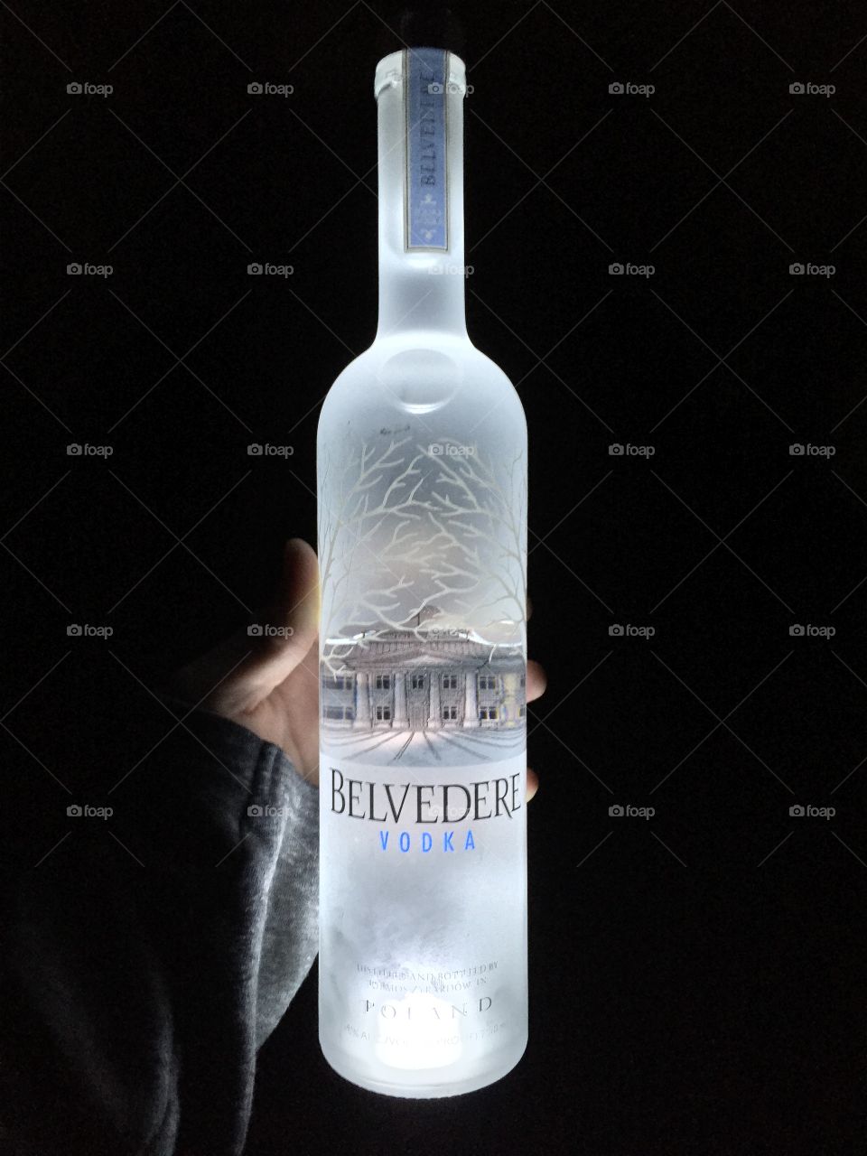 A bottle of Belvedere vodka is illuminated from the bottom. 