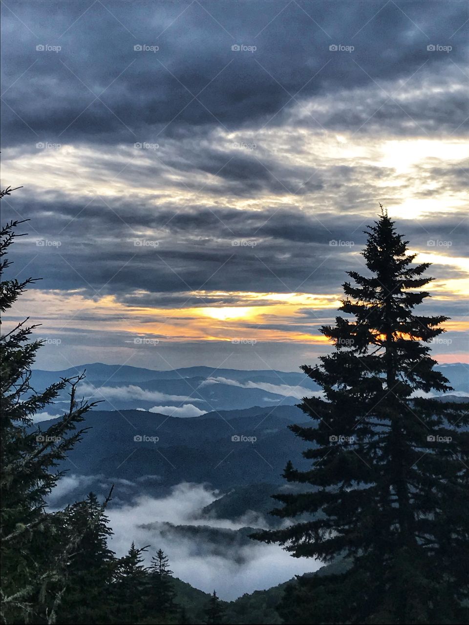 Parkway overlook watching the sunset behind mountain range after mountain range through fog and clouds