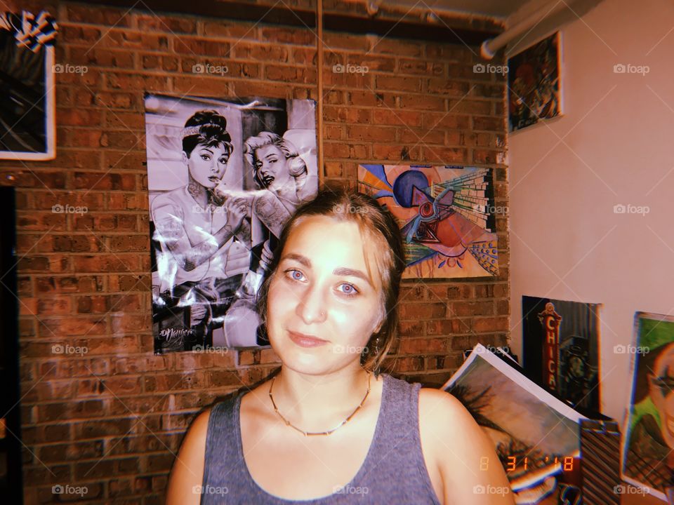 me, posing in front of brick in a hip college dorm room 