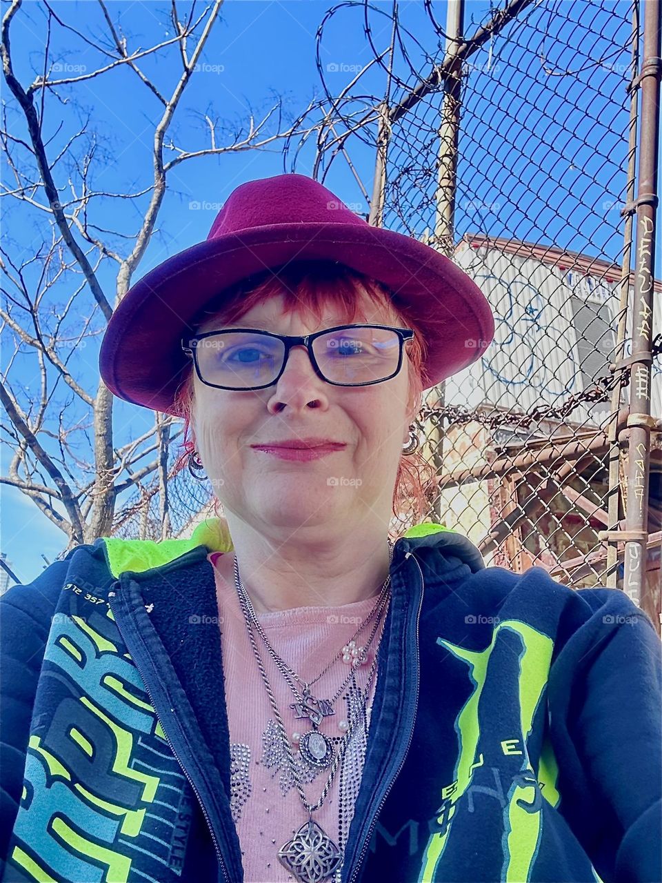 This is me, “Petra Schiller” a.k.a. “Maxine Firefox” standing in the parking lot beneath the “Pulaski Bridge” at “Newtown Creek” in LIC, Queens by the wall we walk along to get to our boat, the “Salvation”. 2024. Hypnotic Productions