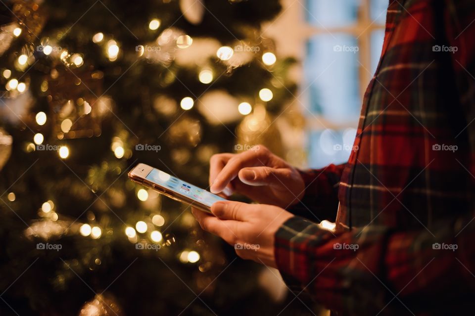young man dials a message on the phone at christmas