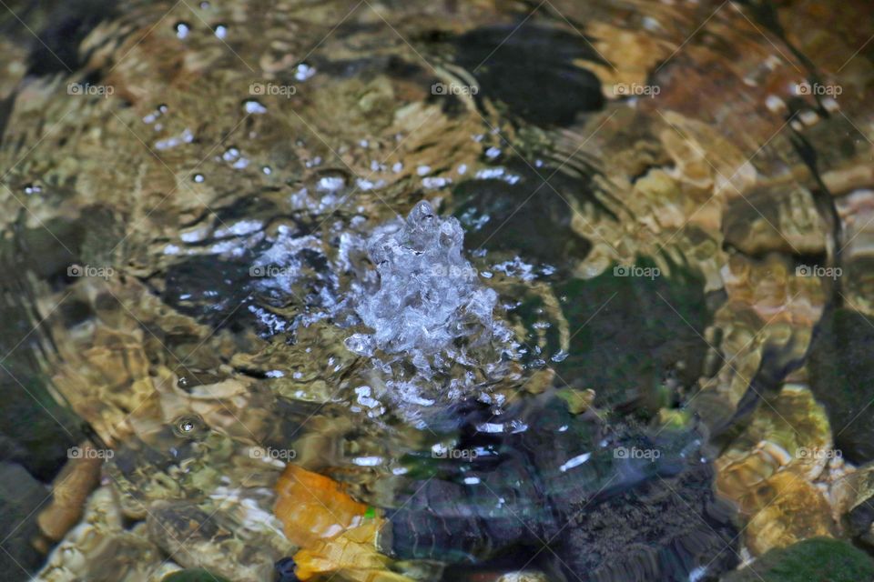 water ripple with crystal splash in the middle of the pond