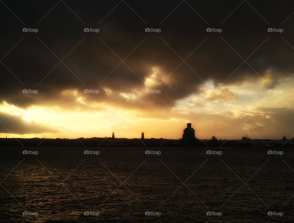 Cloudy sky over calm sea at sunset