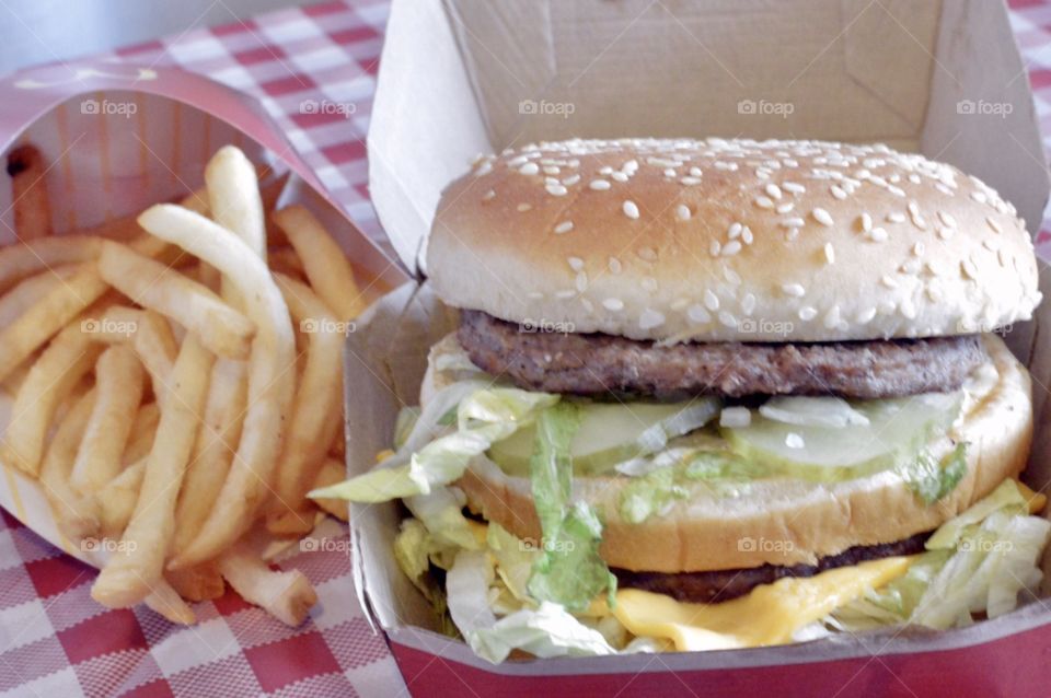 McDonald’s big Mac and a large fry on a red and white checkerboard back ground