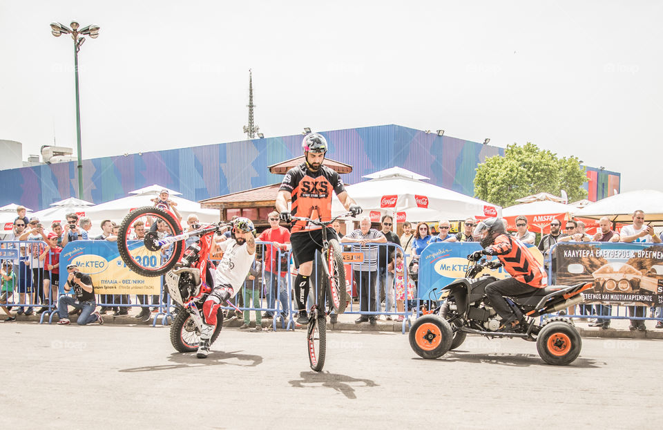 Doing Acrobatics With Quad Bike Terrain Vehicle, Bicycle And Enduro Bike Motocross In Front Of Crowd
