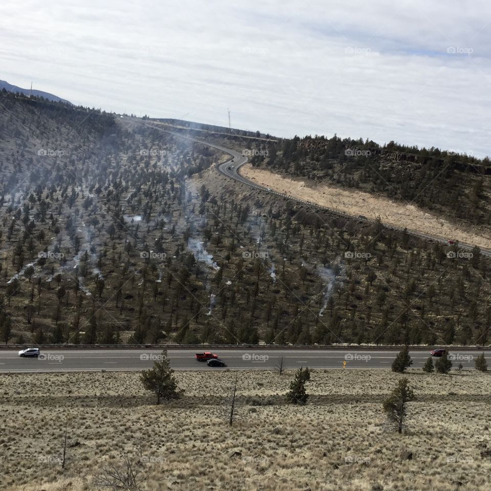 Slash burning on a hill on the side of the highway headed in to Prineville in Central Oregon. 