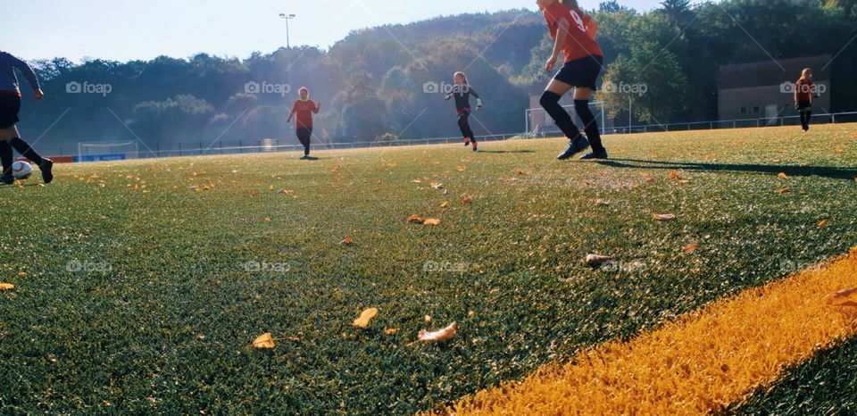 Girls playing soccer on green grass in germany. it is summer.