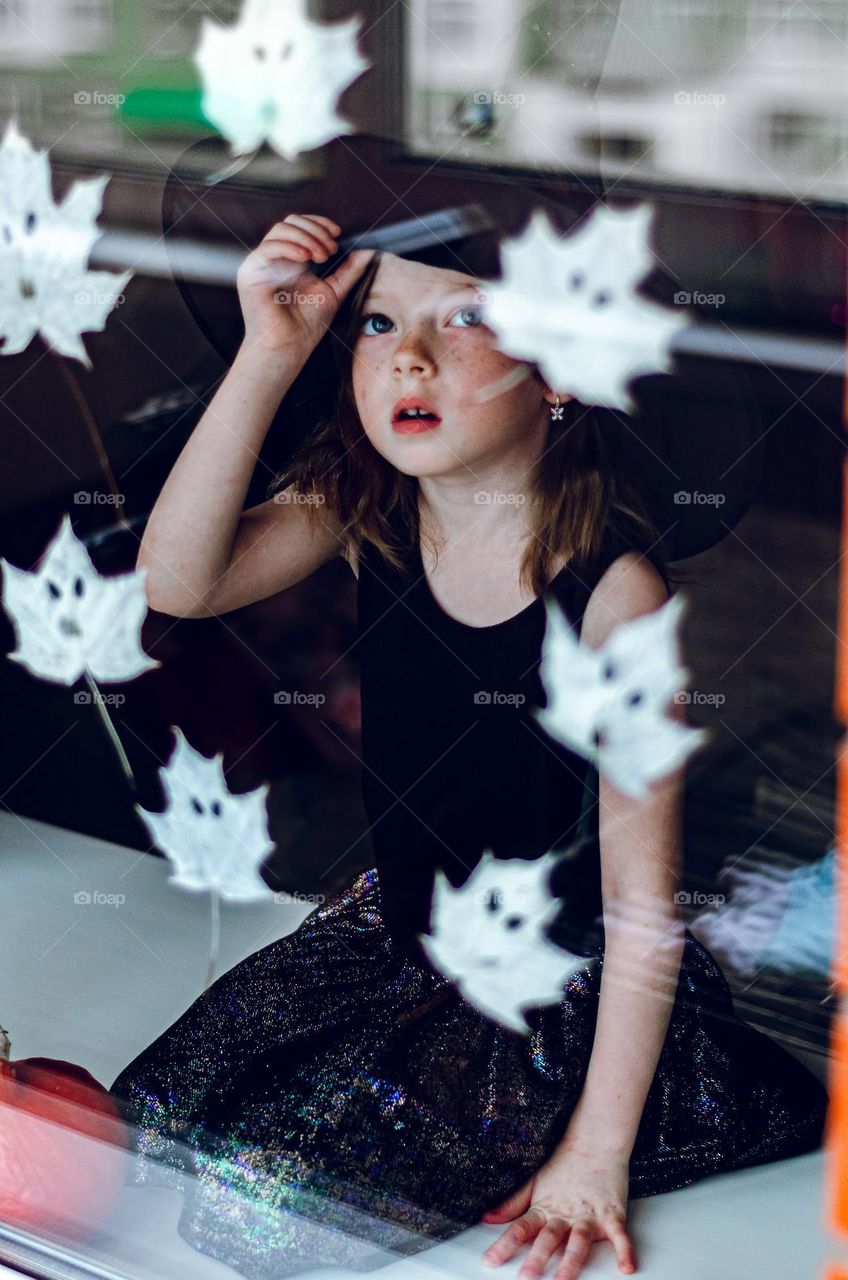 The girl looks out the window with ghosts.