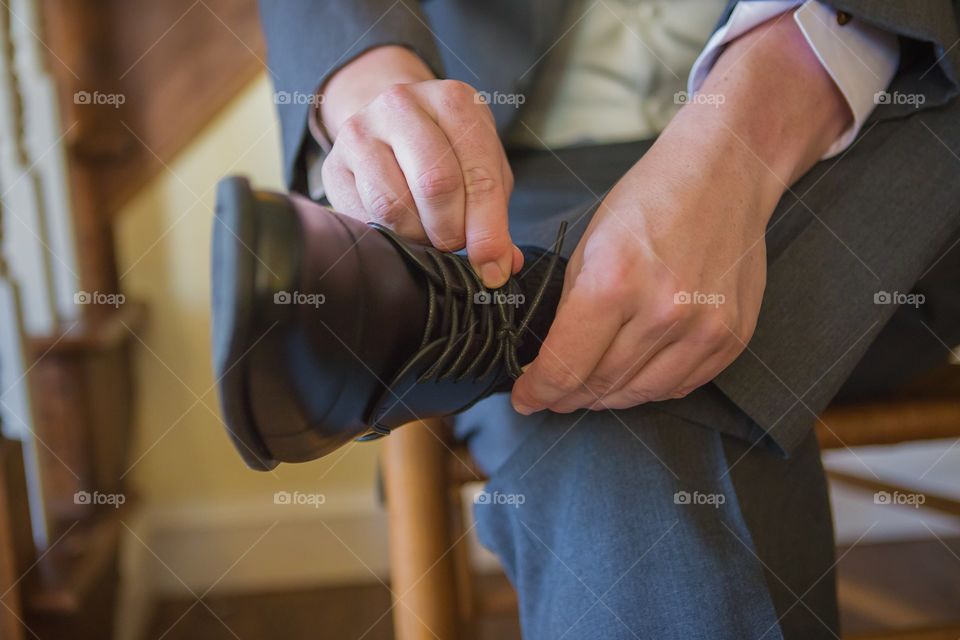 Close-up of man's hand tying his shoe lace
