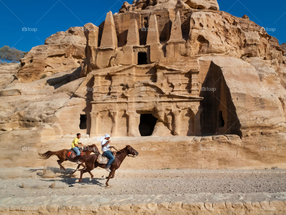 Petra. Lost City. Jordan. Friends horseracing in Al Siq Canyon.