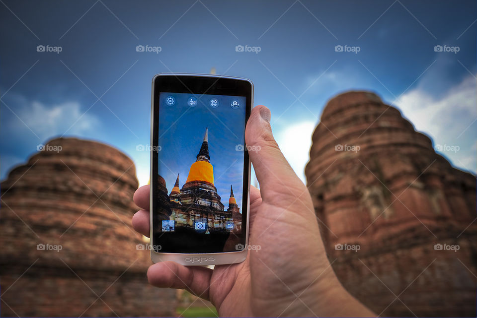 taking picture of Thai Buddhist temple with mobile phone in Ayudhaya