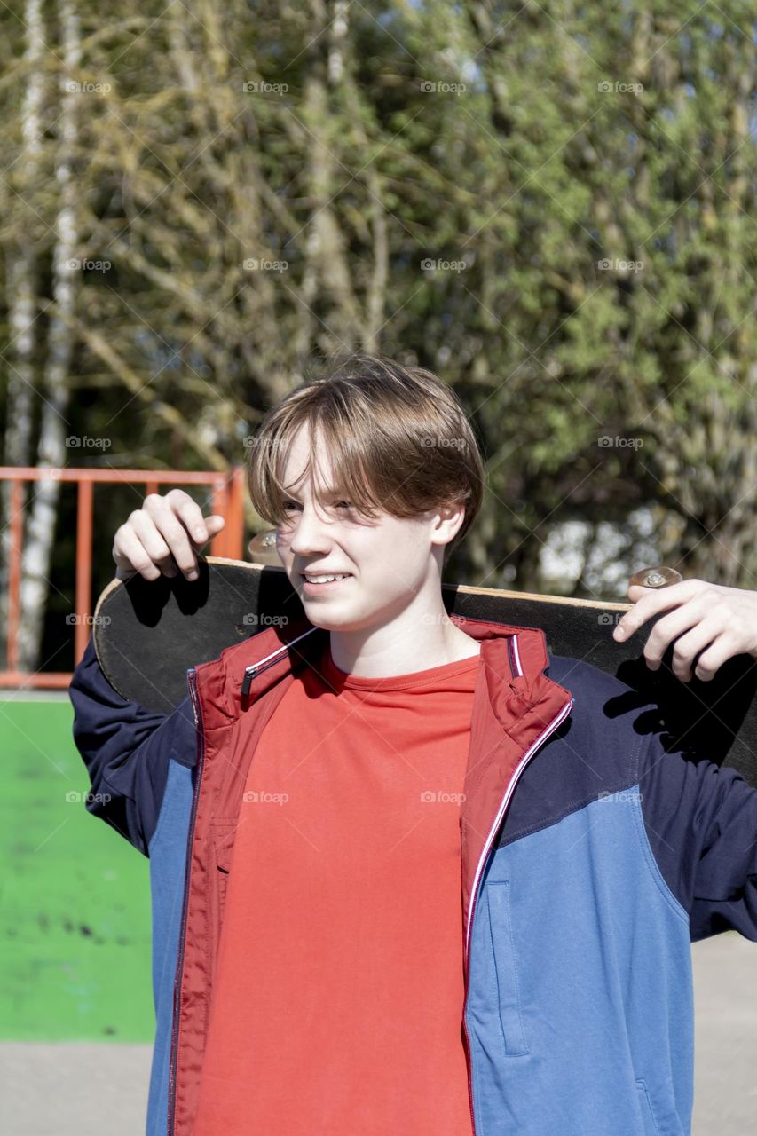 Hobbyist teenager goes in for sports, has fun and rides a skateboard in the park outdoors.