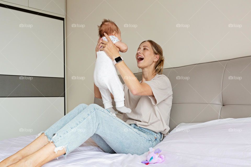 Young Caucasian mother playing with baby at home 