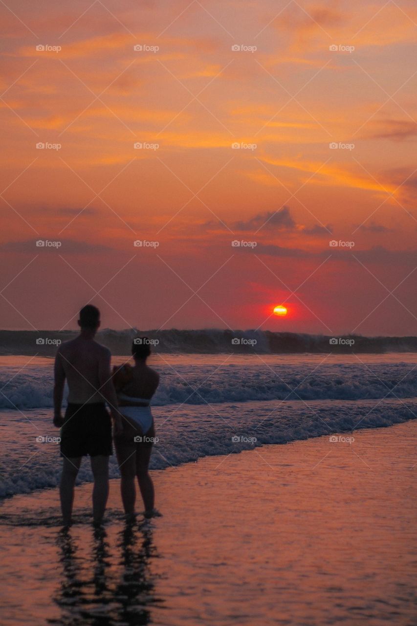 Couple watching sunset on the beach 