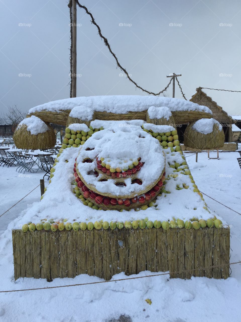 Huge phone covered with snow - made of stray and apples, seen on a local farm in Switzerland 