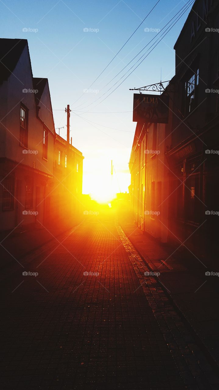 Sunset between the buildings of an English towns street