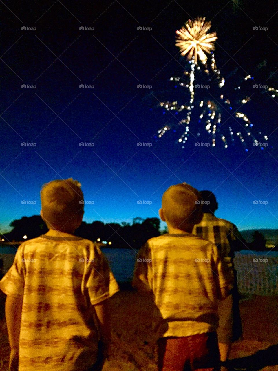 Magic of childhood . Kids being wooed by fireworks. Looks like a wand waving over them