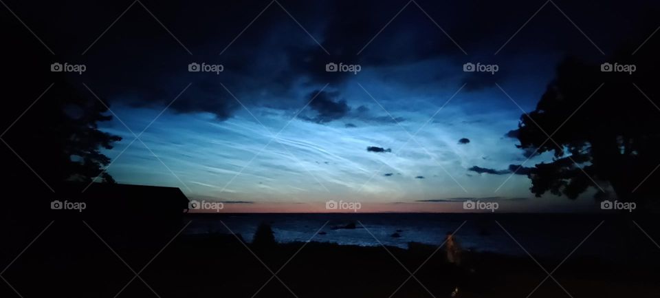 Reflective night clouds in Estonian shore