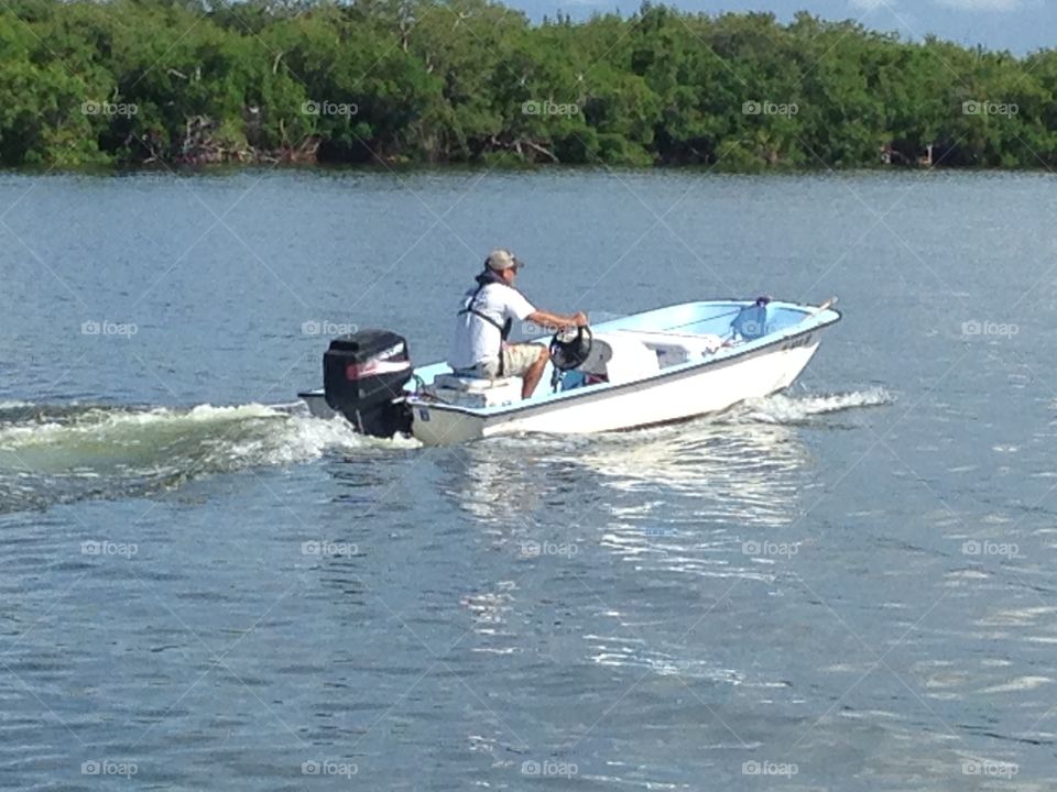 Man on a motorboat near island