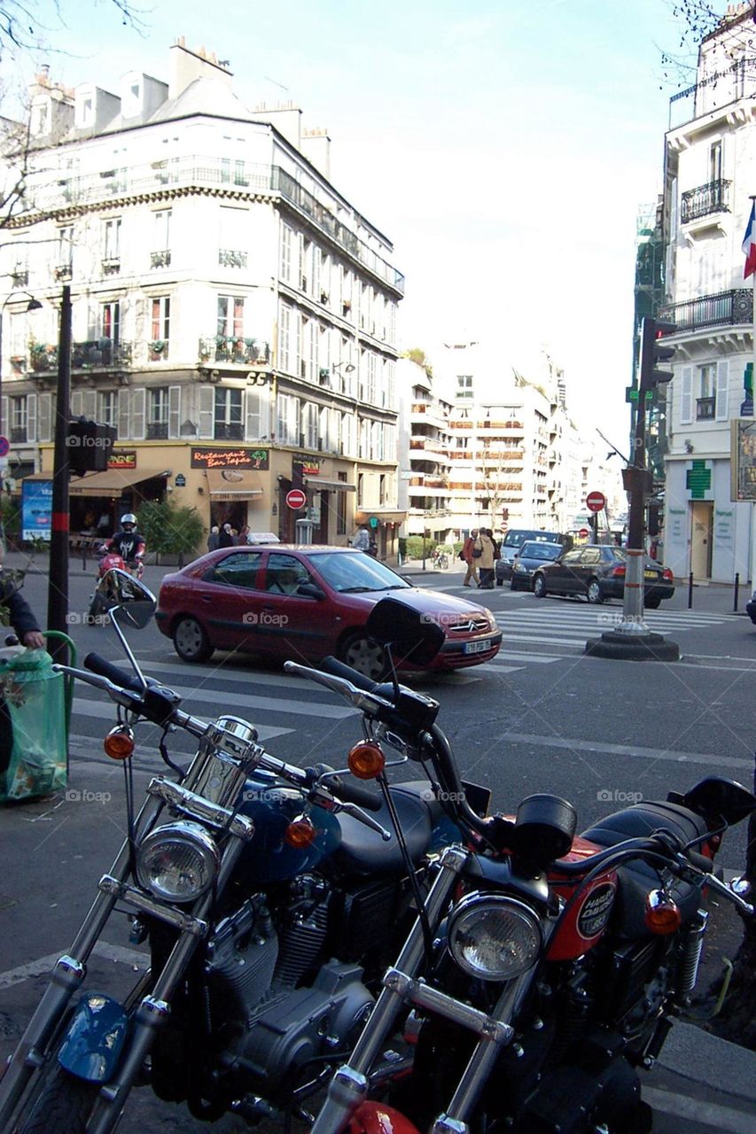 Commuting in motorcycle and parked motorcycles on a street in Paris