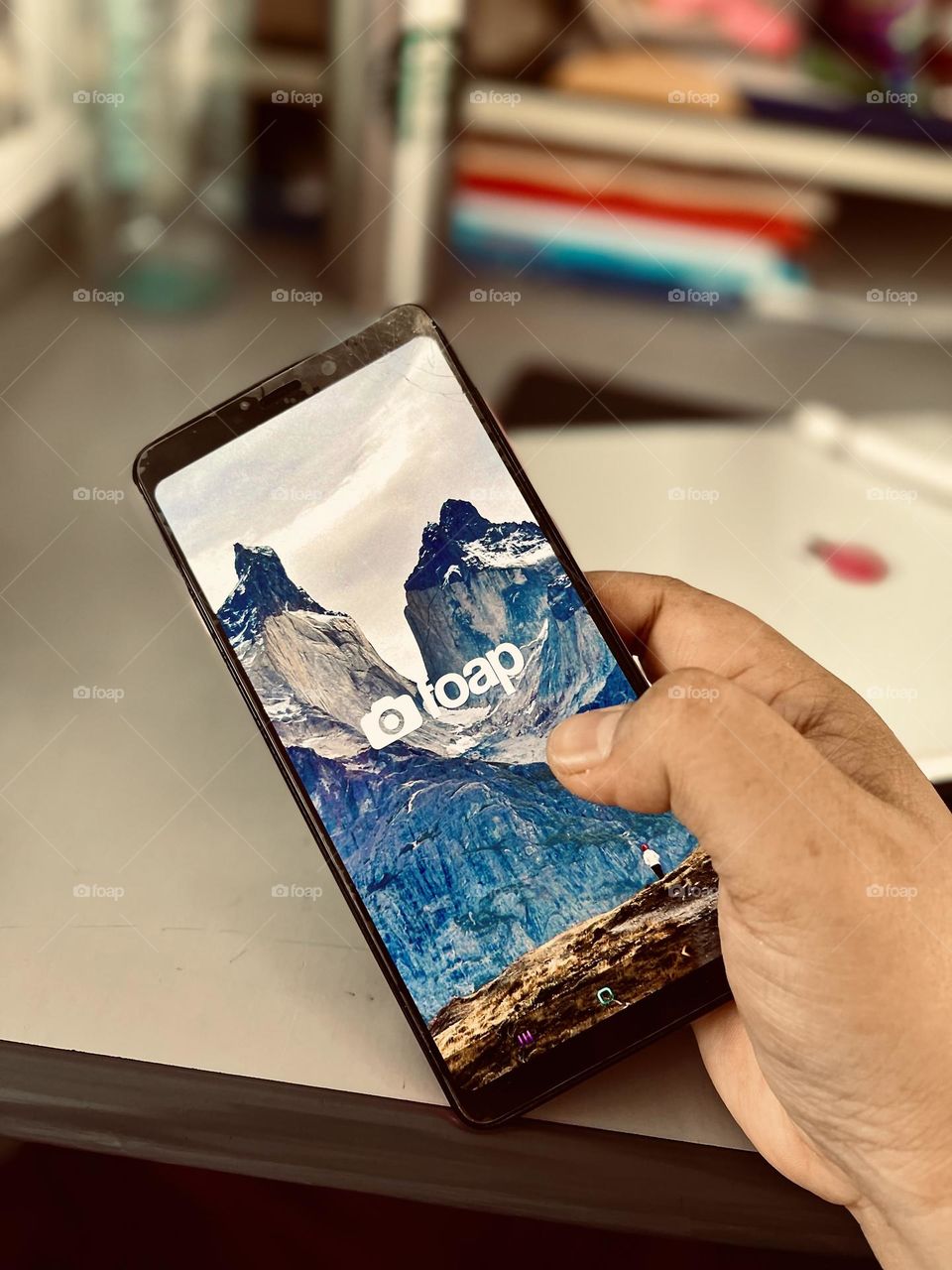 Holding a phone while looking at the screen. View from high angle