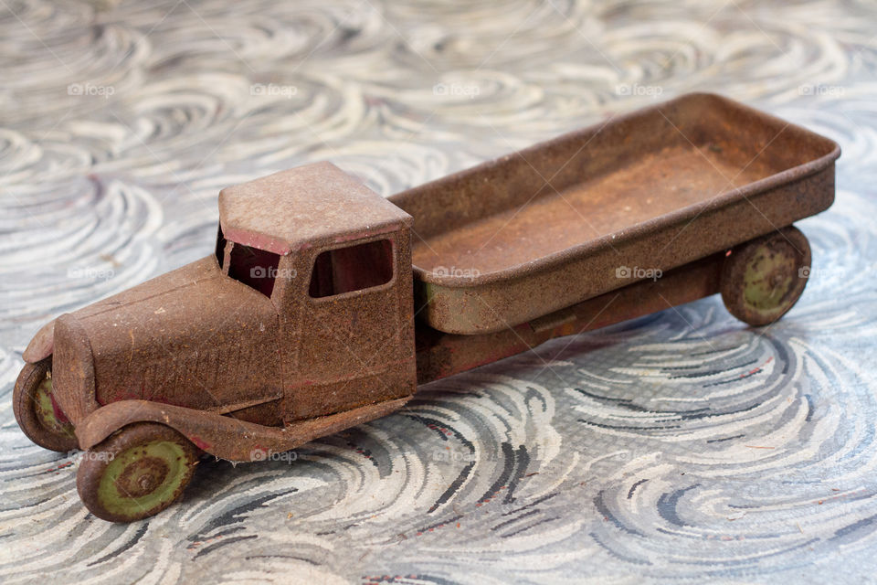 Rusted antique toy truck on a linoleum floor