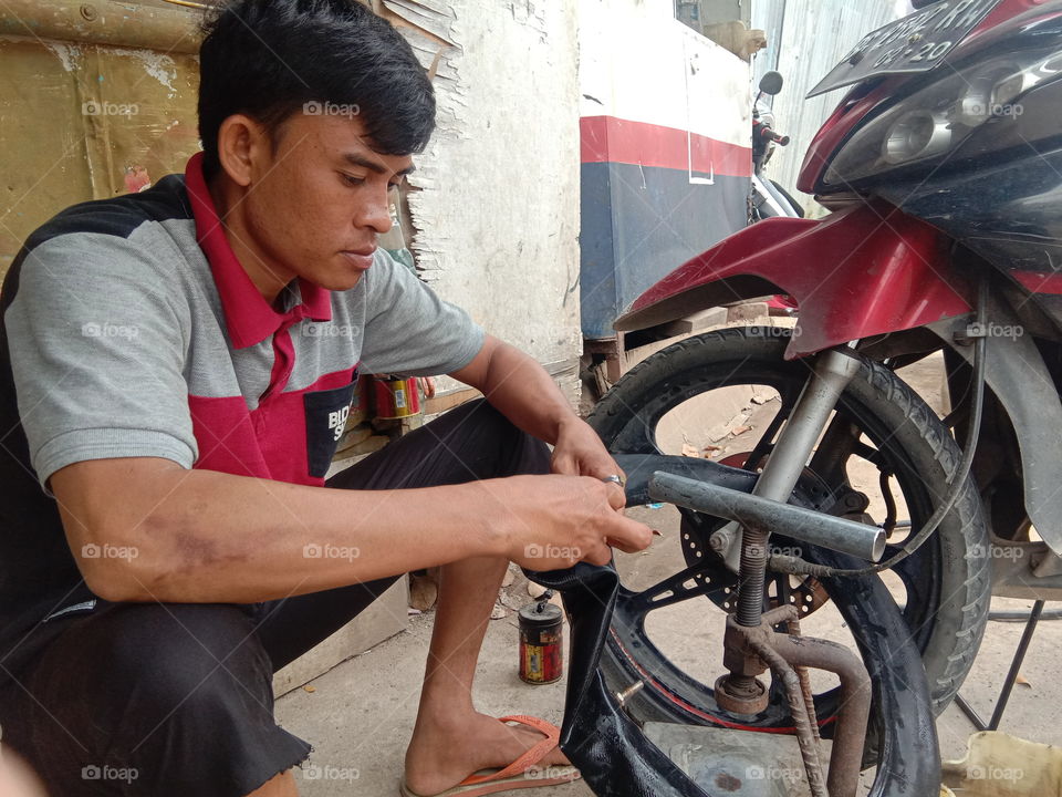 Motorcycle repair workers are using the tire removal tool inside to repair patches