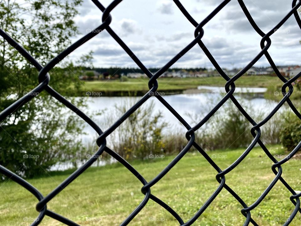 Metal fencing with a lake view.