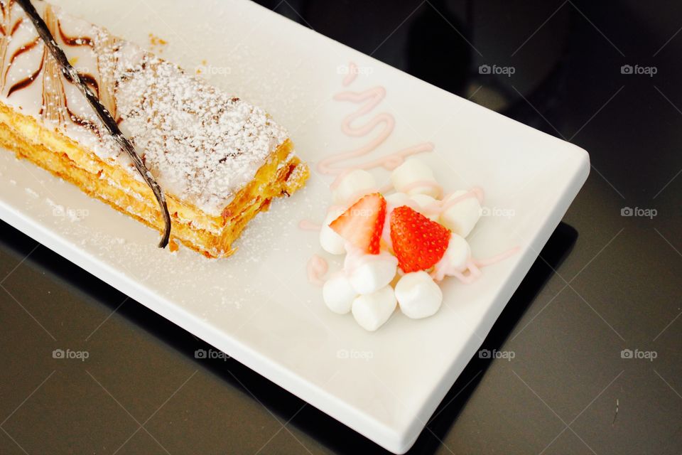 High angle view of mille feuille on plate against black background