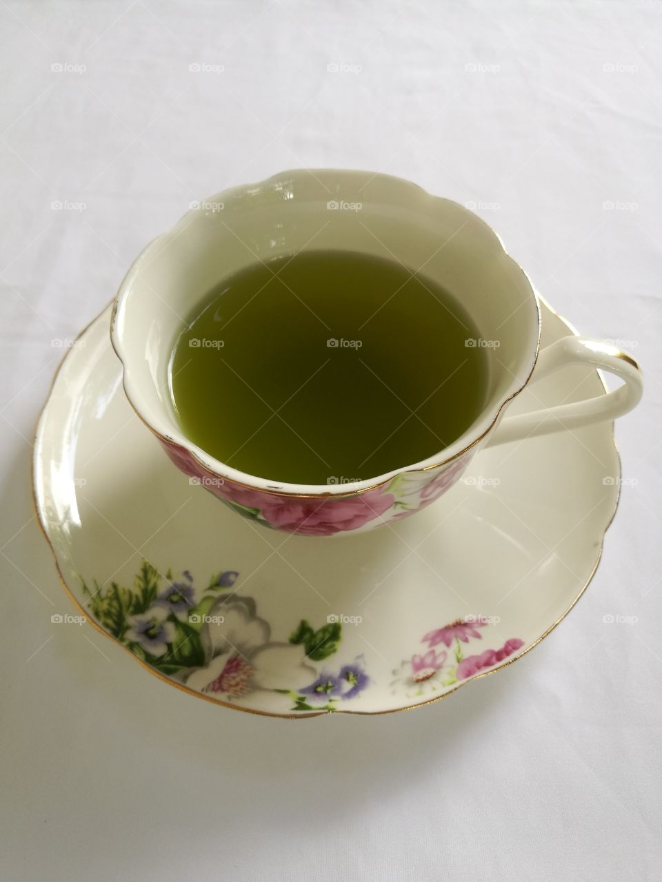 A cup of green tea isolated on white background.