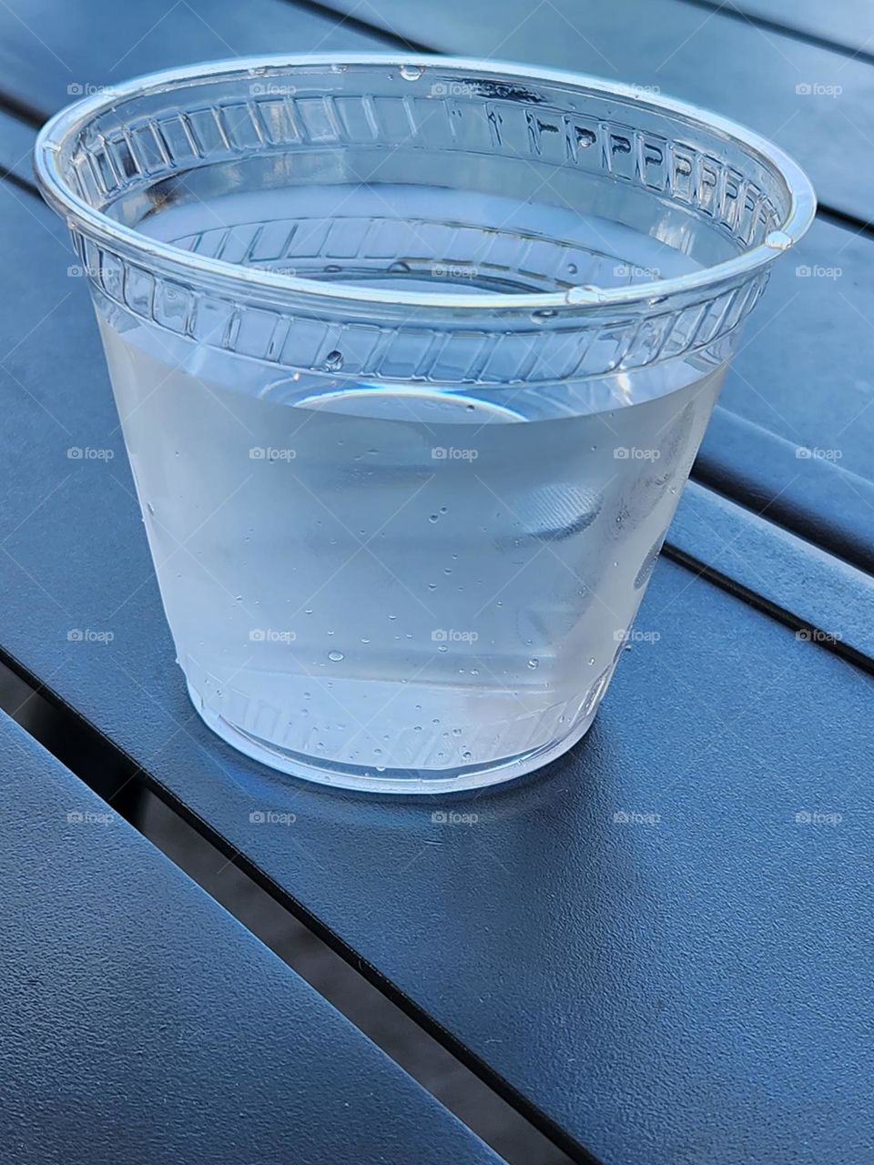 plastic cup of water on outdoor restaurant table