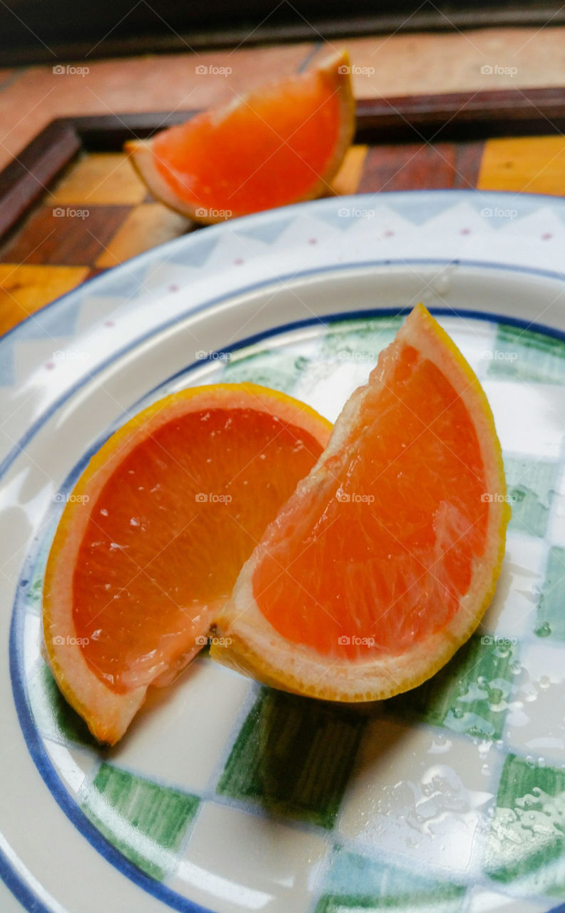 A freshly cut grapefruit on a plate with a geometric pattern