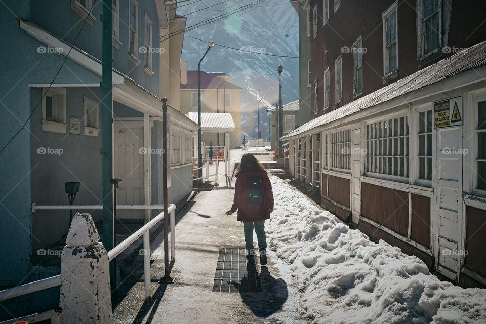 Woman walked through a snowy passage from an old neighborhood