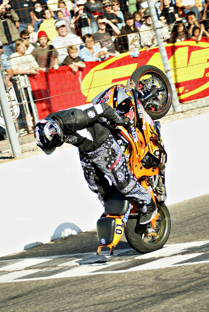 Yamaha sponsored rider nearly scraping the tail across the finish line in a backwards wheelie at a racetrack in Lake Havasu.