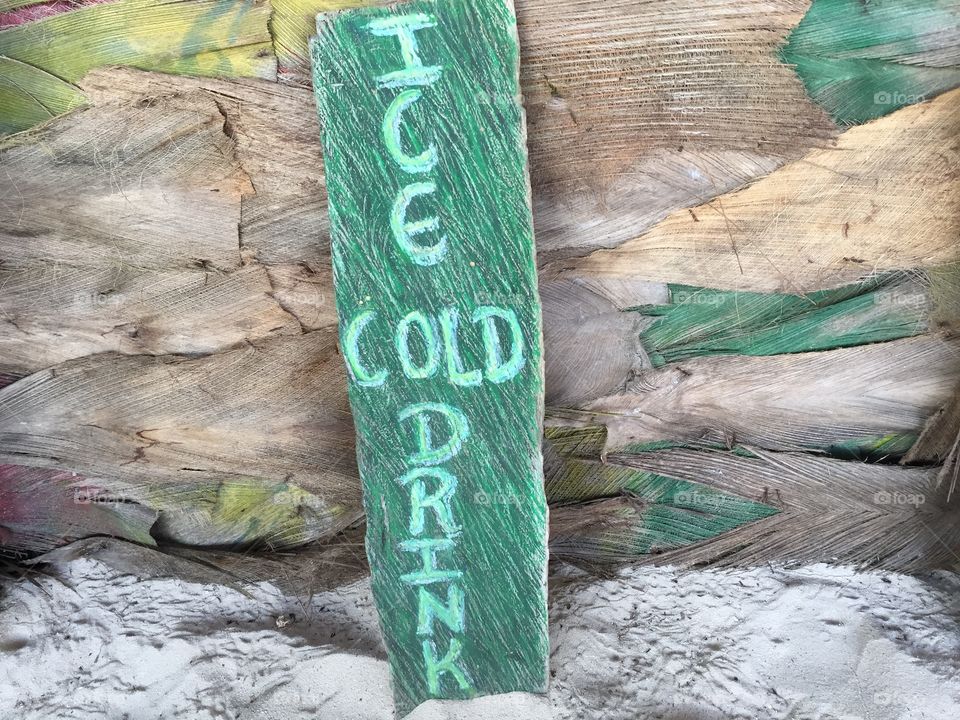 Wooden plate with text Ice cold drink at the beach