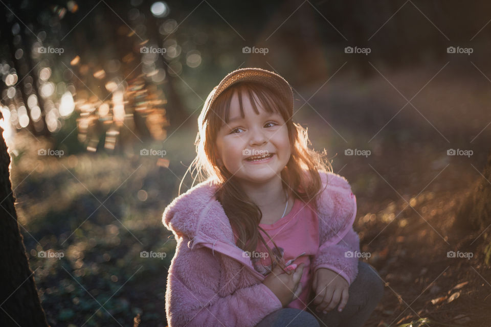 Little girl in evening forest. 