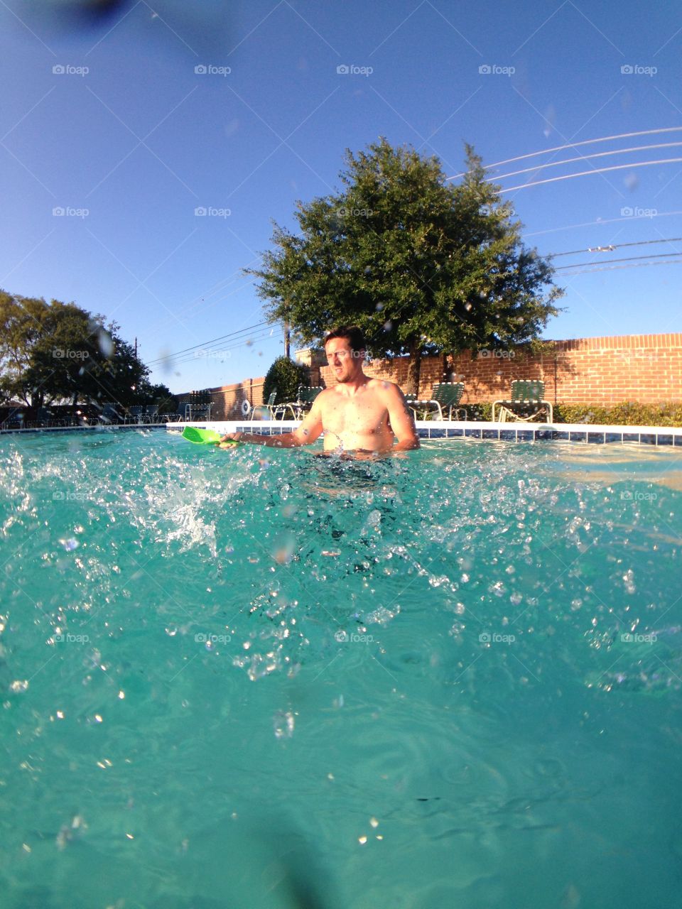 Don't splash dad. Dad playing a water game in the pool