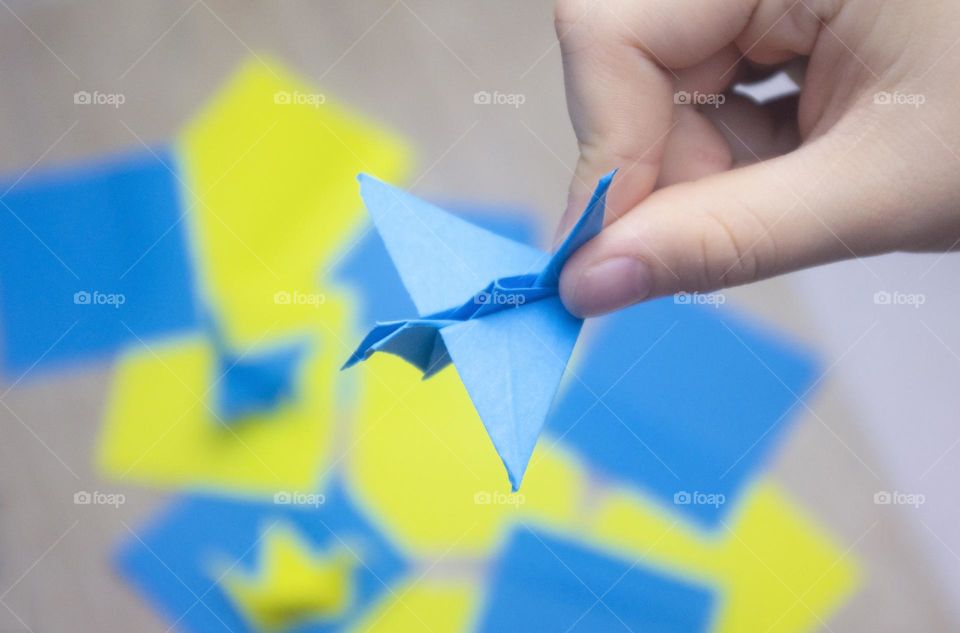 a child makes a crane out of paper