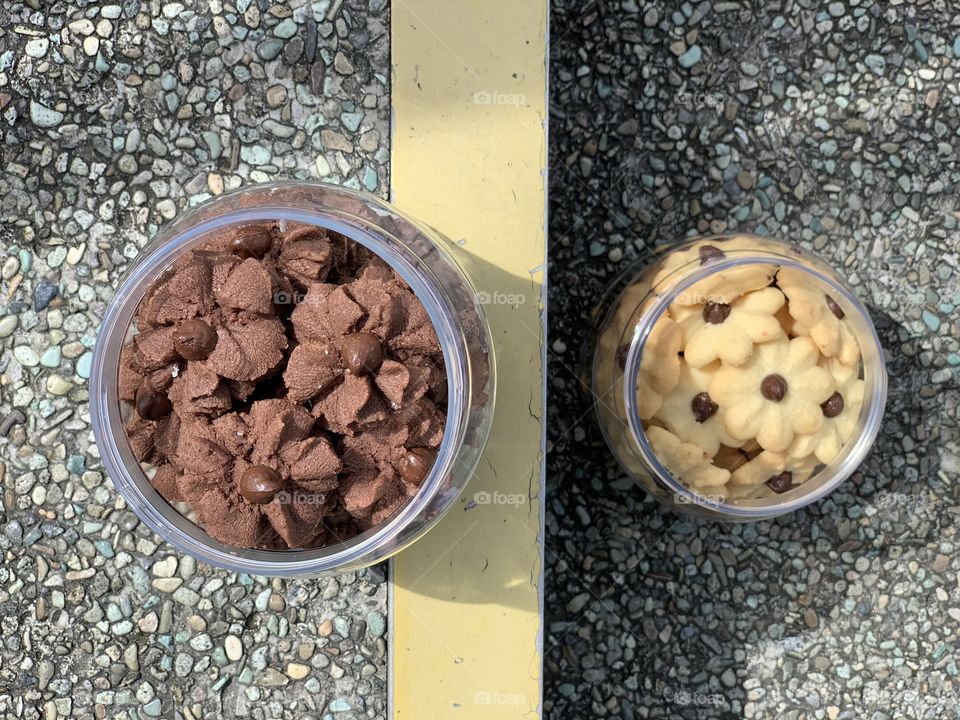 Dark chocolate chips cookies and almond butter cookies in a green nature background , freshly baked