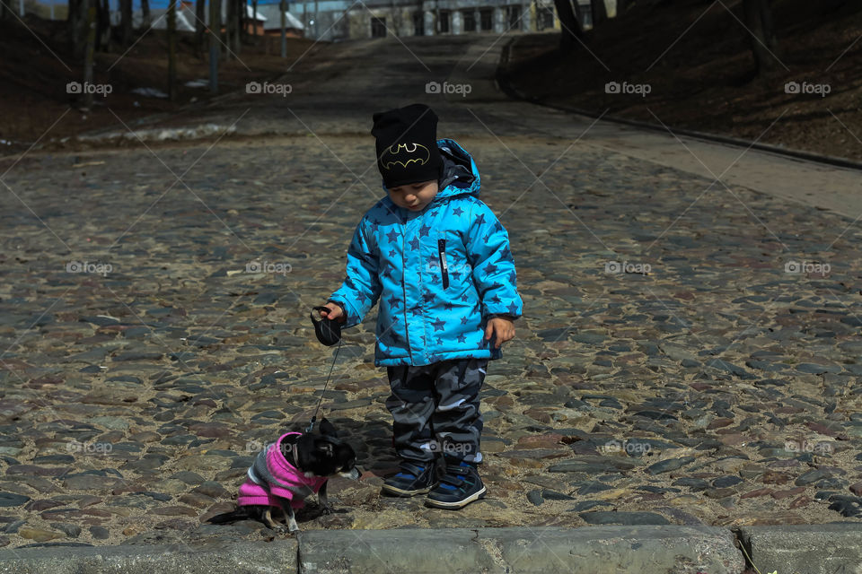 the boy walks with a dog