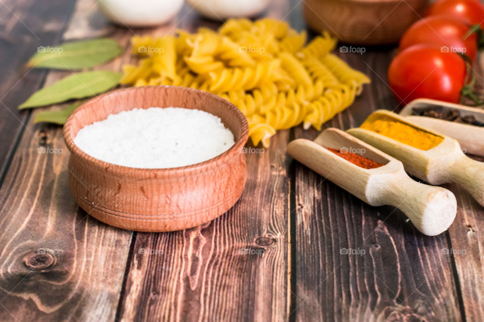 Raw pasta with ingredients and wooden accessories