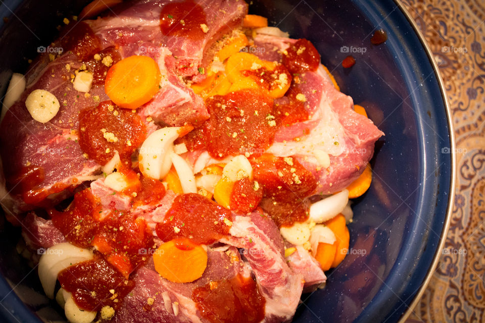 Red meat and ingredients in a cooking container ready to be put in the stove