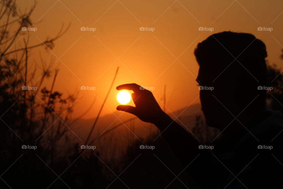 sun in hand during sunset
