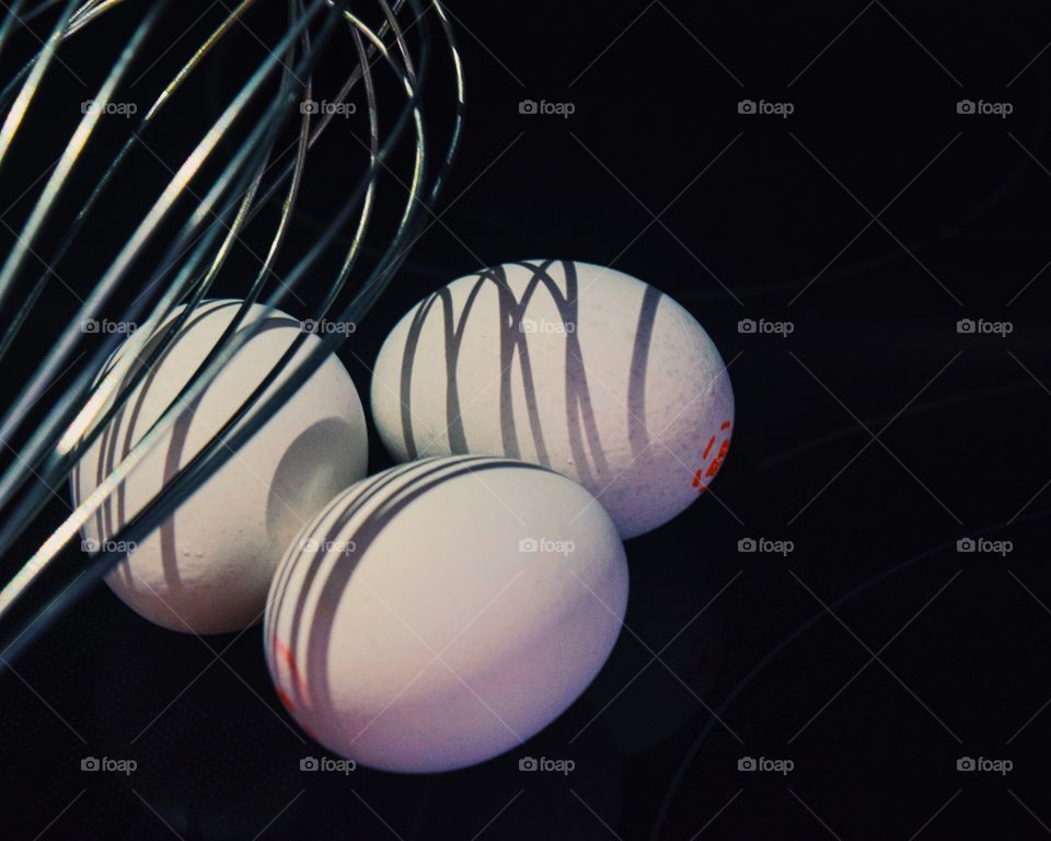 Shadow of a whisk on a group of eggs