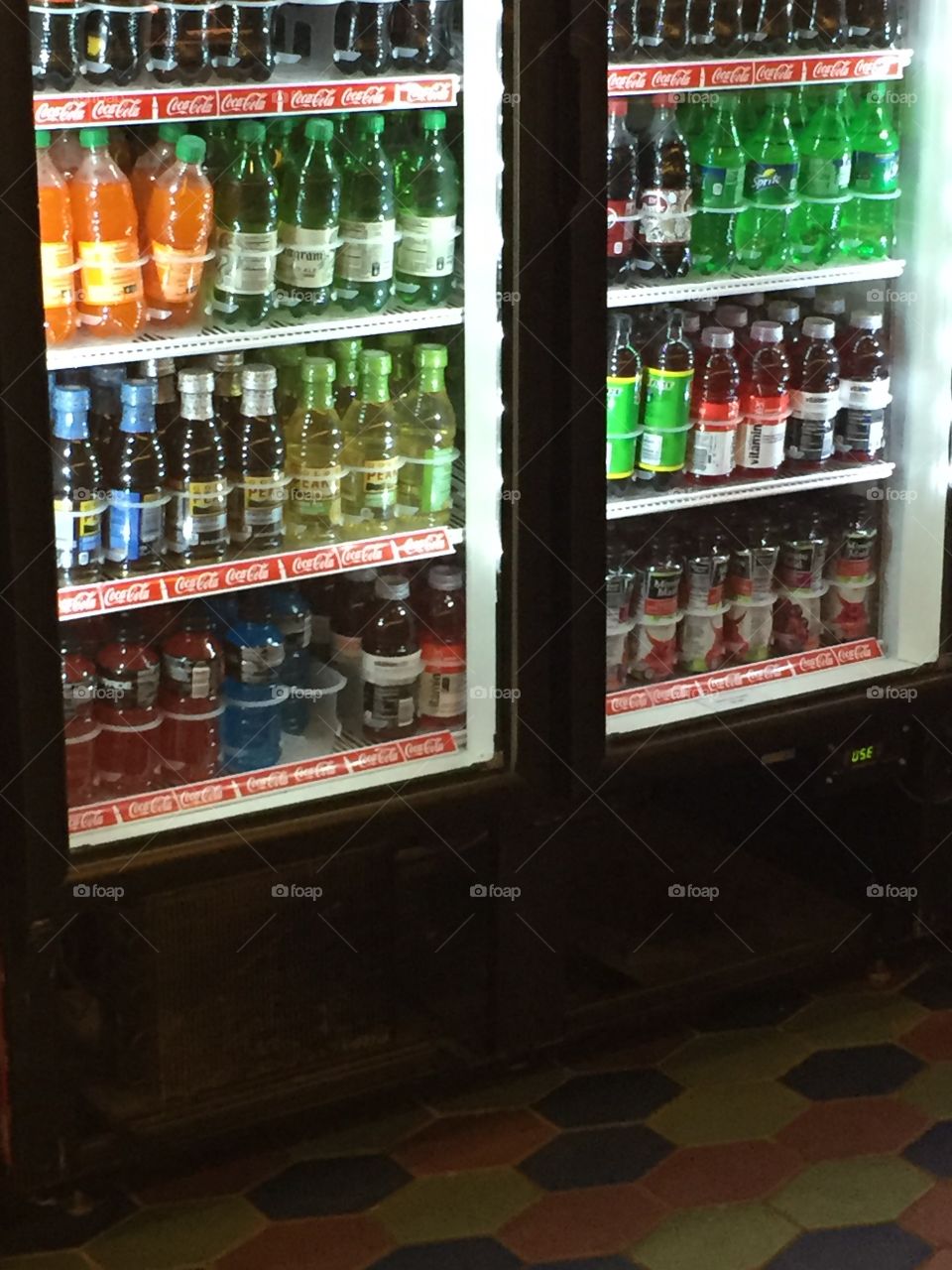 Resturant / store beverage refrigerator filled with many soda pop drink bottles. 