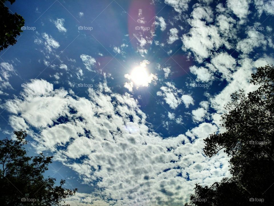 glowing sun surrounded by white clowds