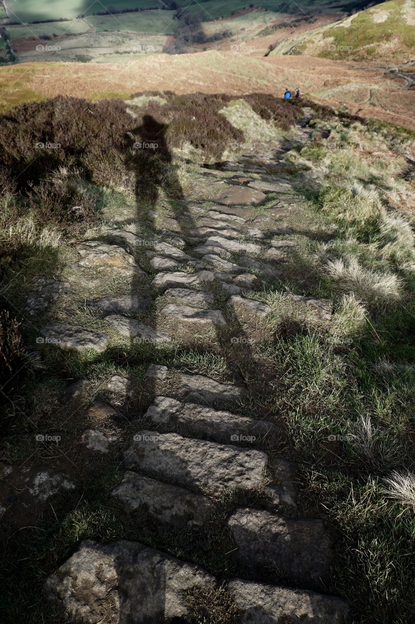 View of person's shadow on rocks