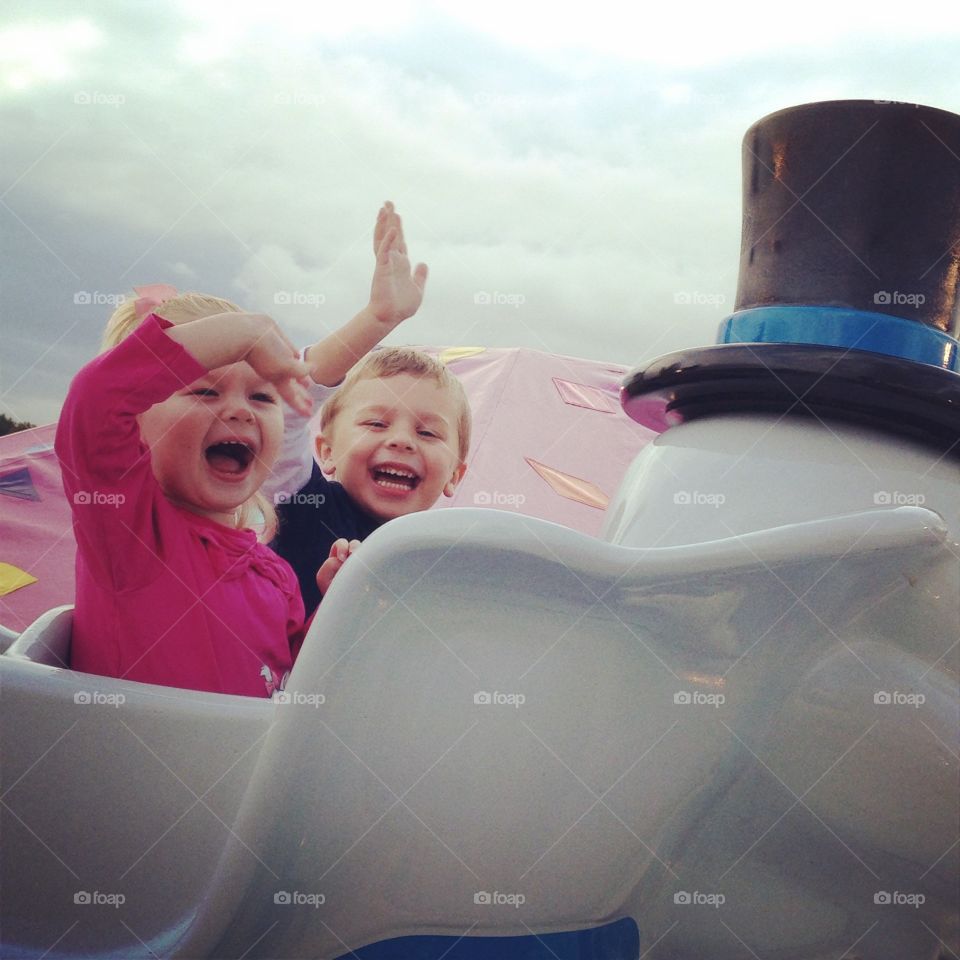 Amusement ride. Happy kids riding a ride