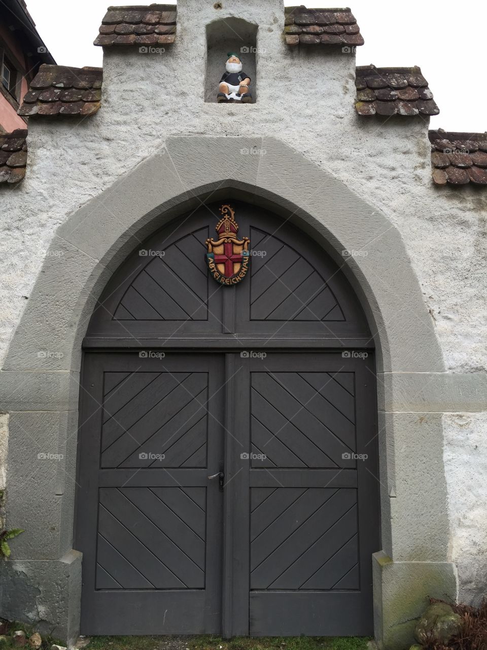 Wooden door with Ornaments and a funny dwarf above