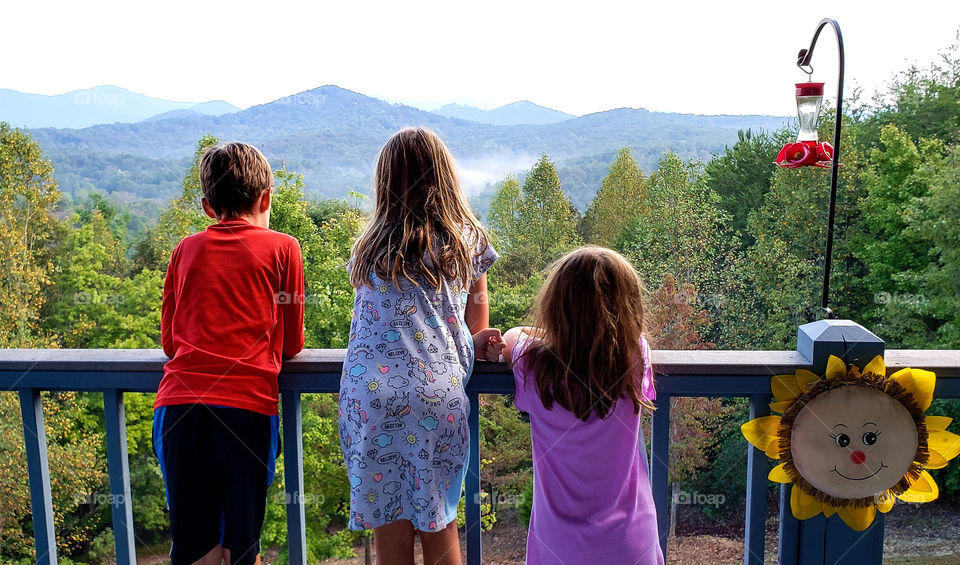 Three kids enjoying mountain view.